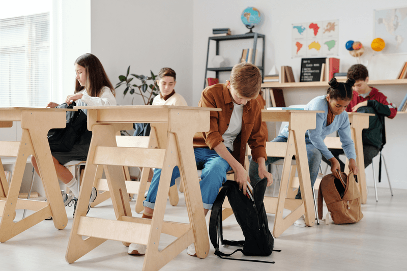 Foto van schoolklas met kinderen die boeken uit hun schooltas halen