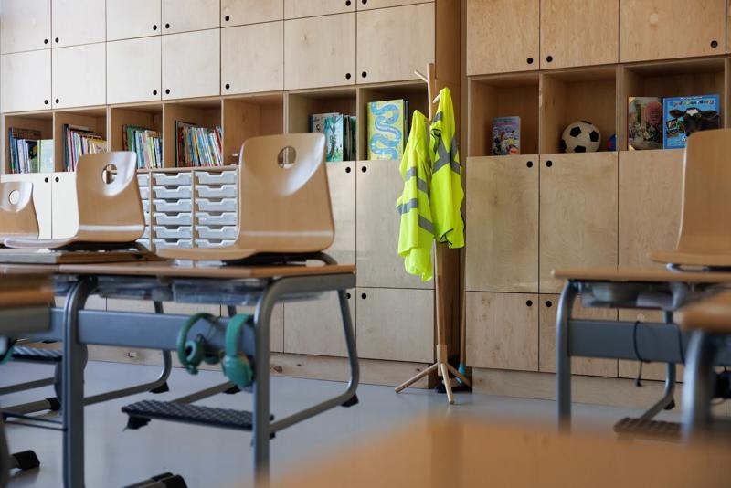 Leeg klaslokaal met twee gele arbo-hesjes